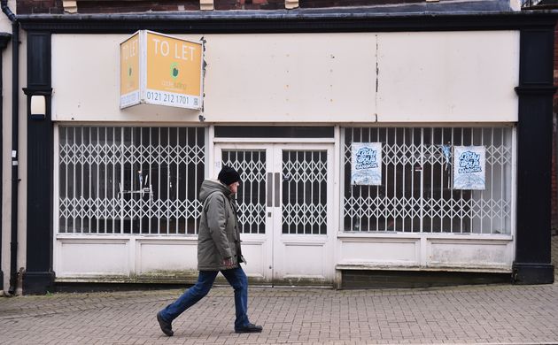 A man walks past an empty shop in Burslem.